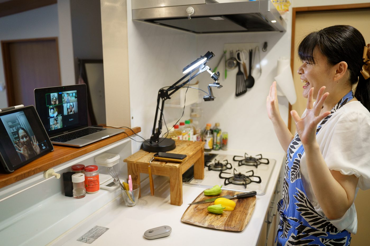 キッチンでパソコンとタブレットを使い、オンライン料理教室をする藤田さん